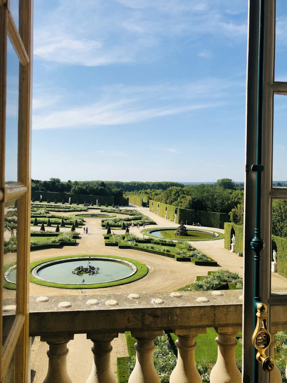 campo di erba verde vicino agli alberi verdi sotto il cielo blu durante il giorno