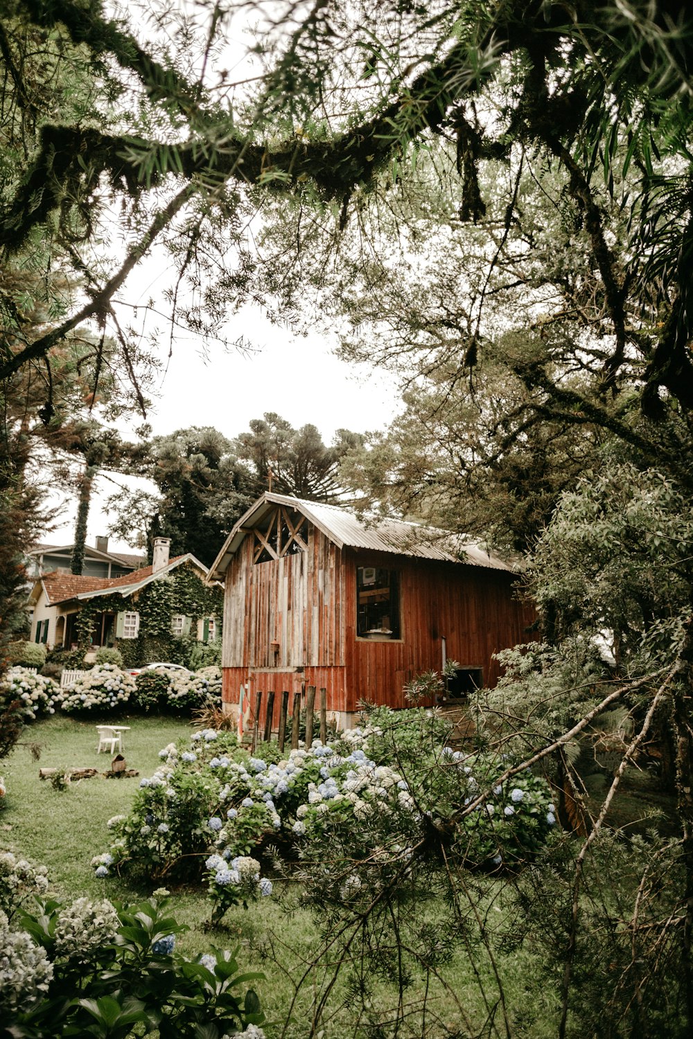 brown wooden house surrounded by green trees during daytime