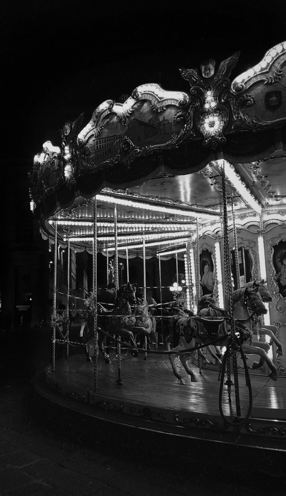 grayscale photo of carousel with people