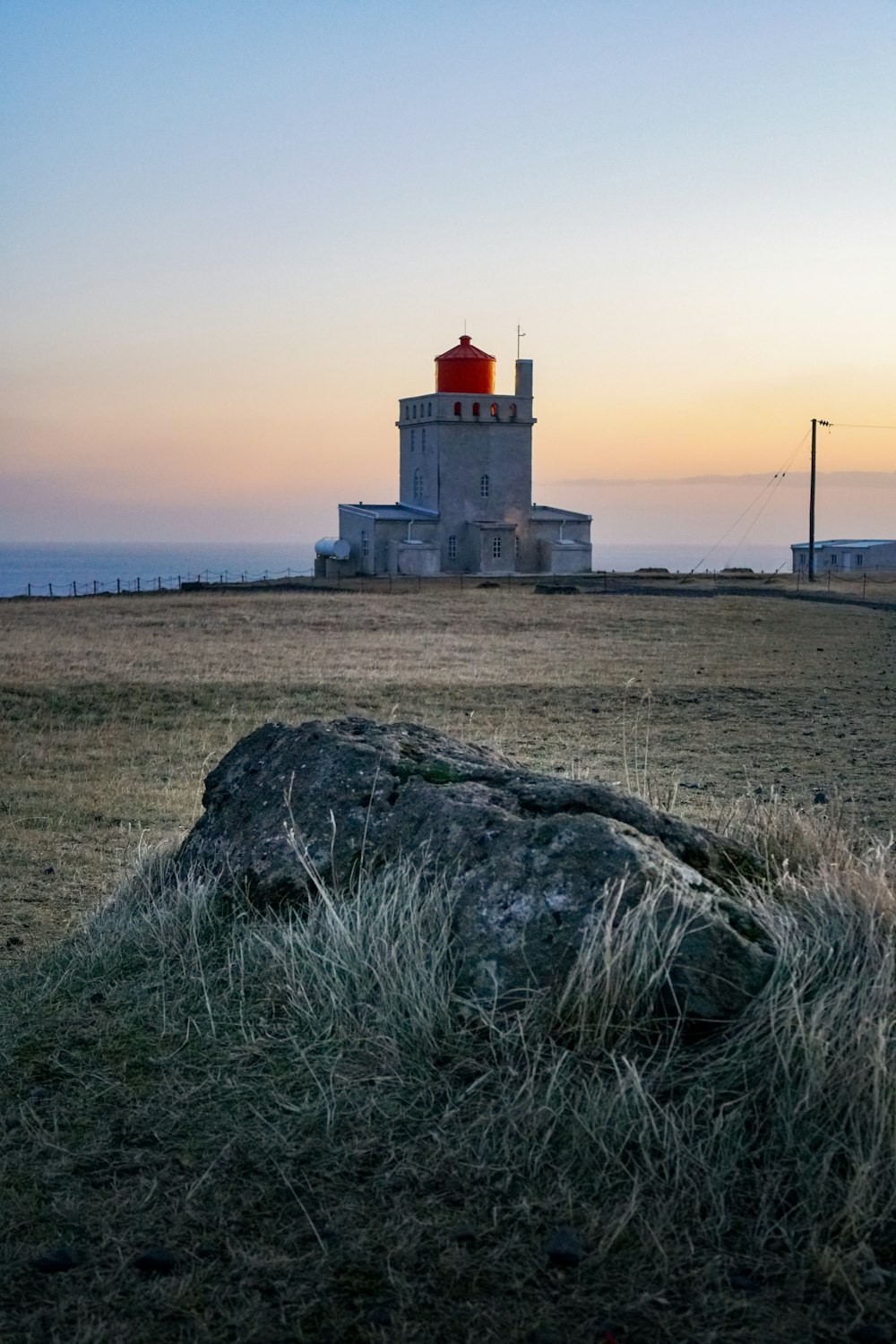 white and red lighthouse on green grass field during daytime