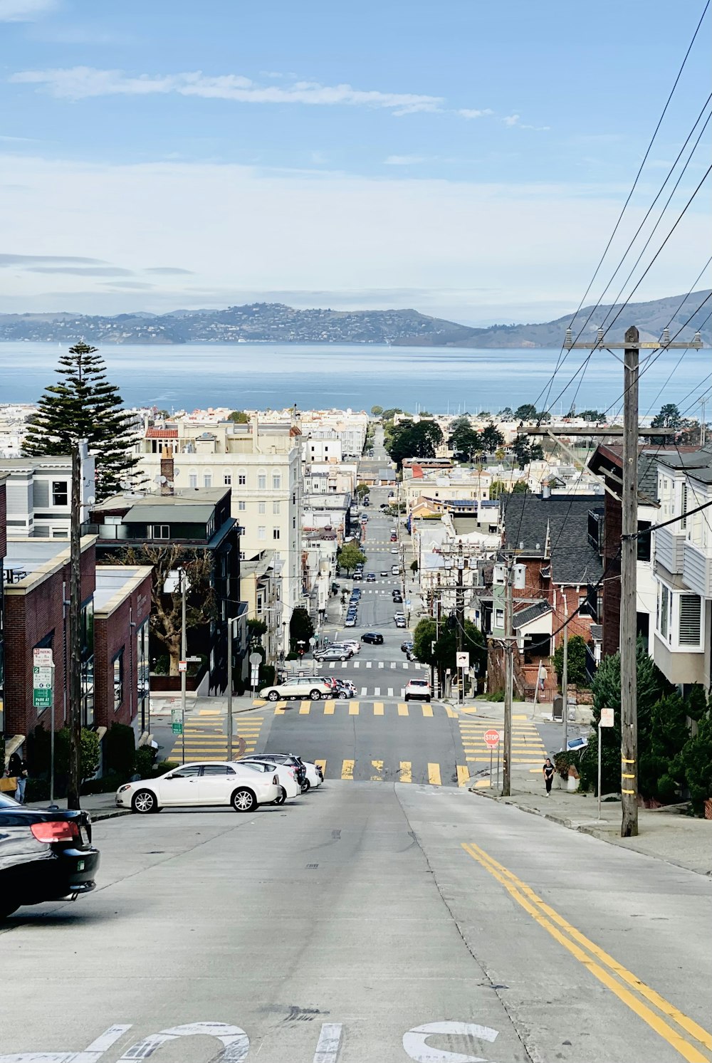 cars parked on side of the road near buildings during daytime