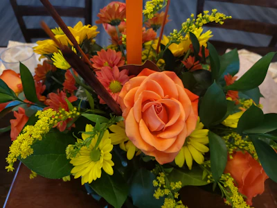 Festive centerpiece featuring bold red and orange blooms for celebrations.