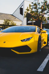 A vibrant yellow sports car parked under natural light highlighting its curves.