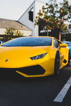 A vibrant yellow sports car parked under natural light highlighting its curves.