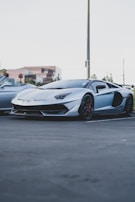 A sporty coupe shining under bright sunlight on a city street.