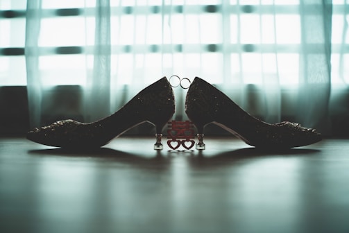 Selection of handmade heels arranged artistically with floral accents and cozy lighting