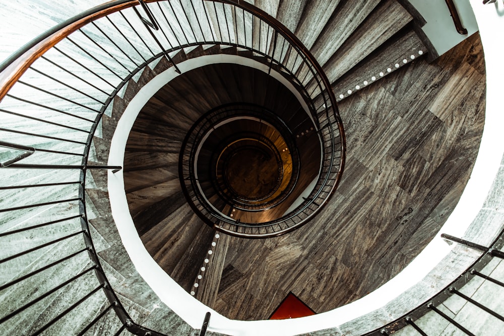 brown spiral staircase with brown wooden railings