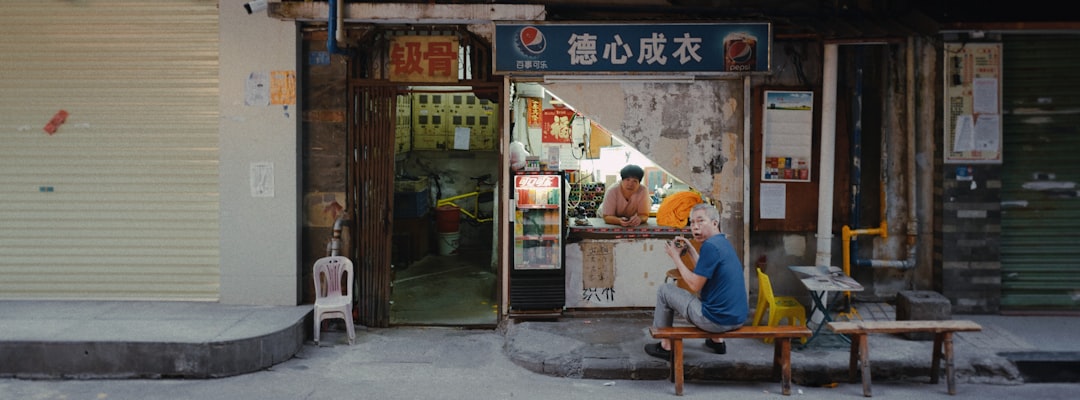 man in blue t-shirt sitting on white plastic chair