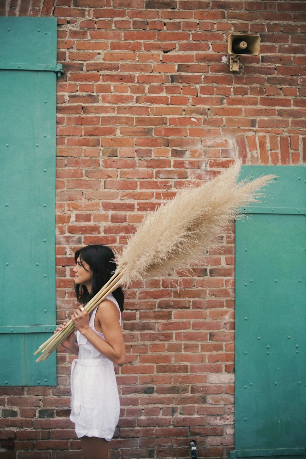 woman in white tank top holding broom