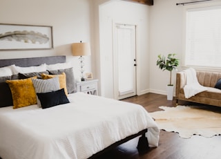 white bed linen near white wooden door