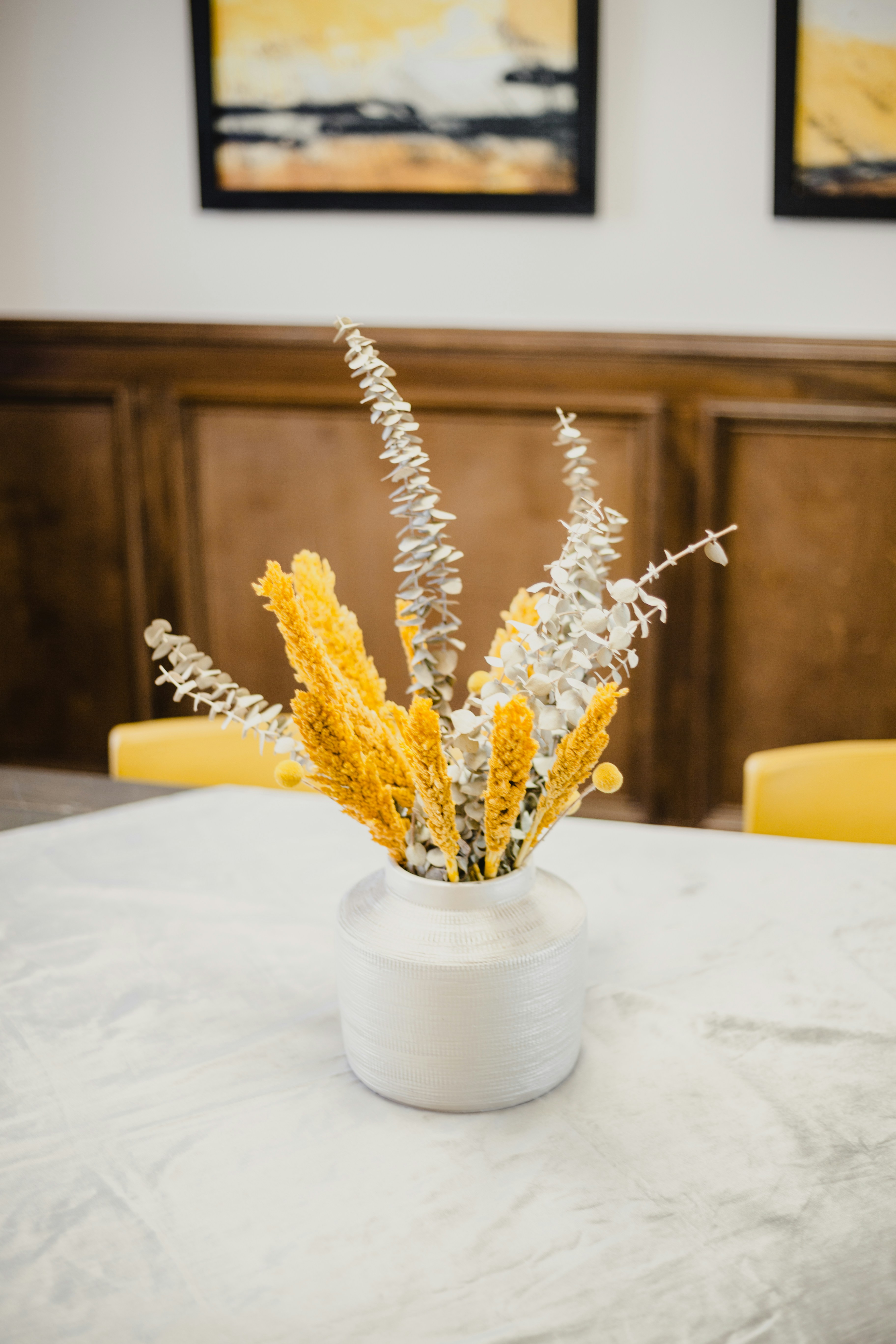 yellow flowers in white ceramic vase