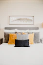 Close-up of plush bedding with black and gold pillows in a modern suite.