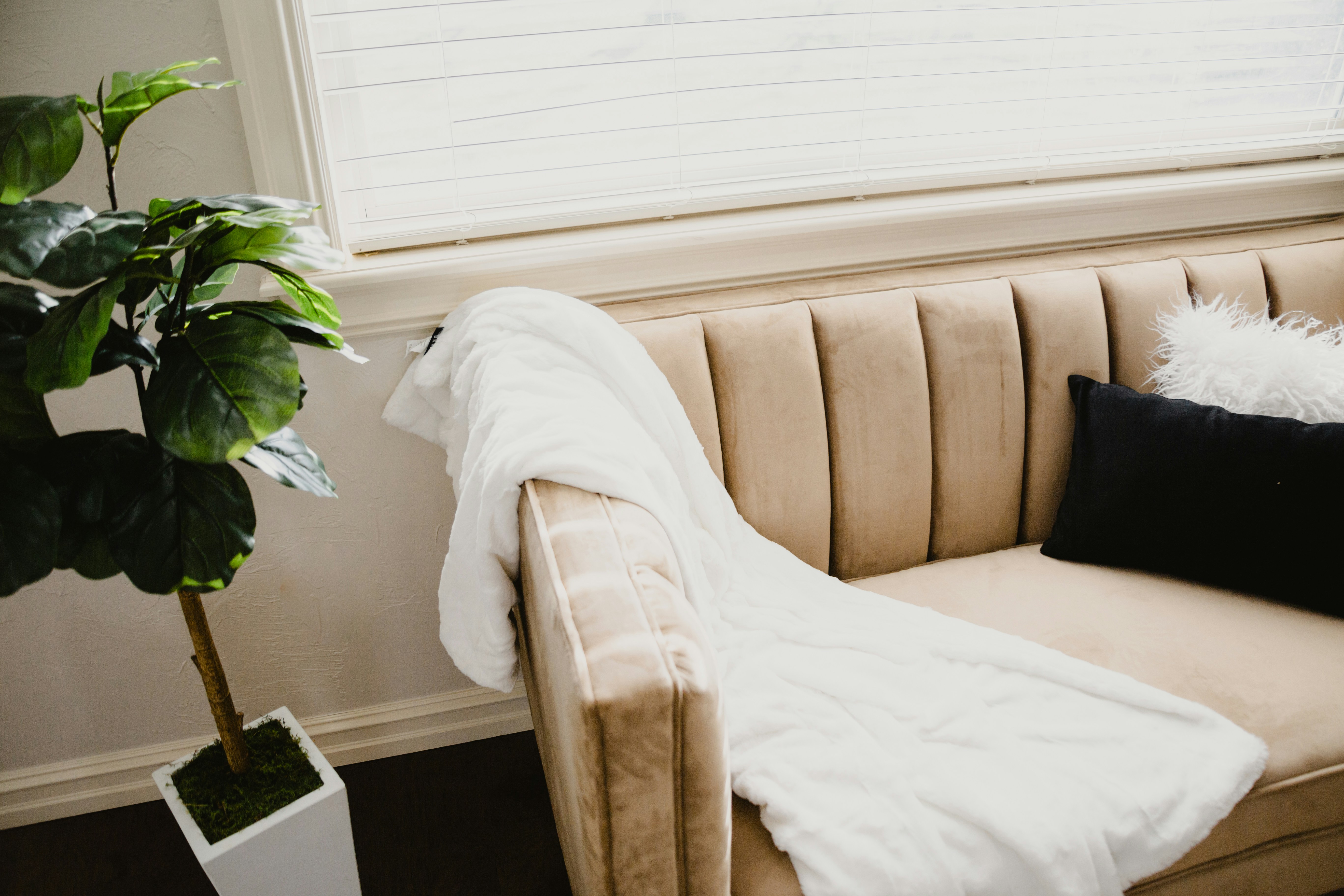 white bed linen near white window blinds