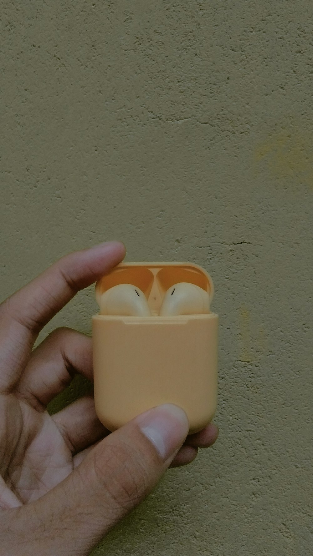 person holding beige plastic container