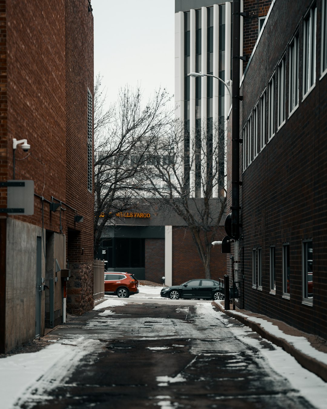 black car parked beside brown building during daytime