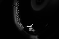 Close-up of a handcrafted steering wheel with fine leather stitching.