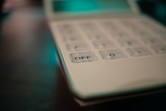 Close-up of hands using a financial calculator with green and white color tones.