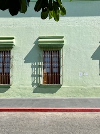 green and white concrete building with blue wooden window