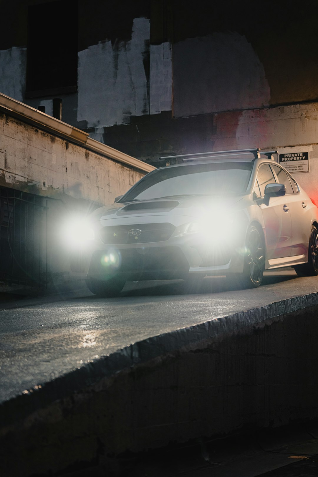 white car parked beside wall