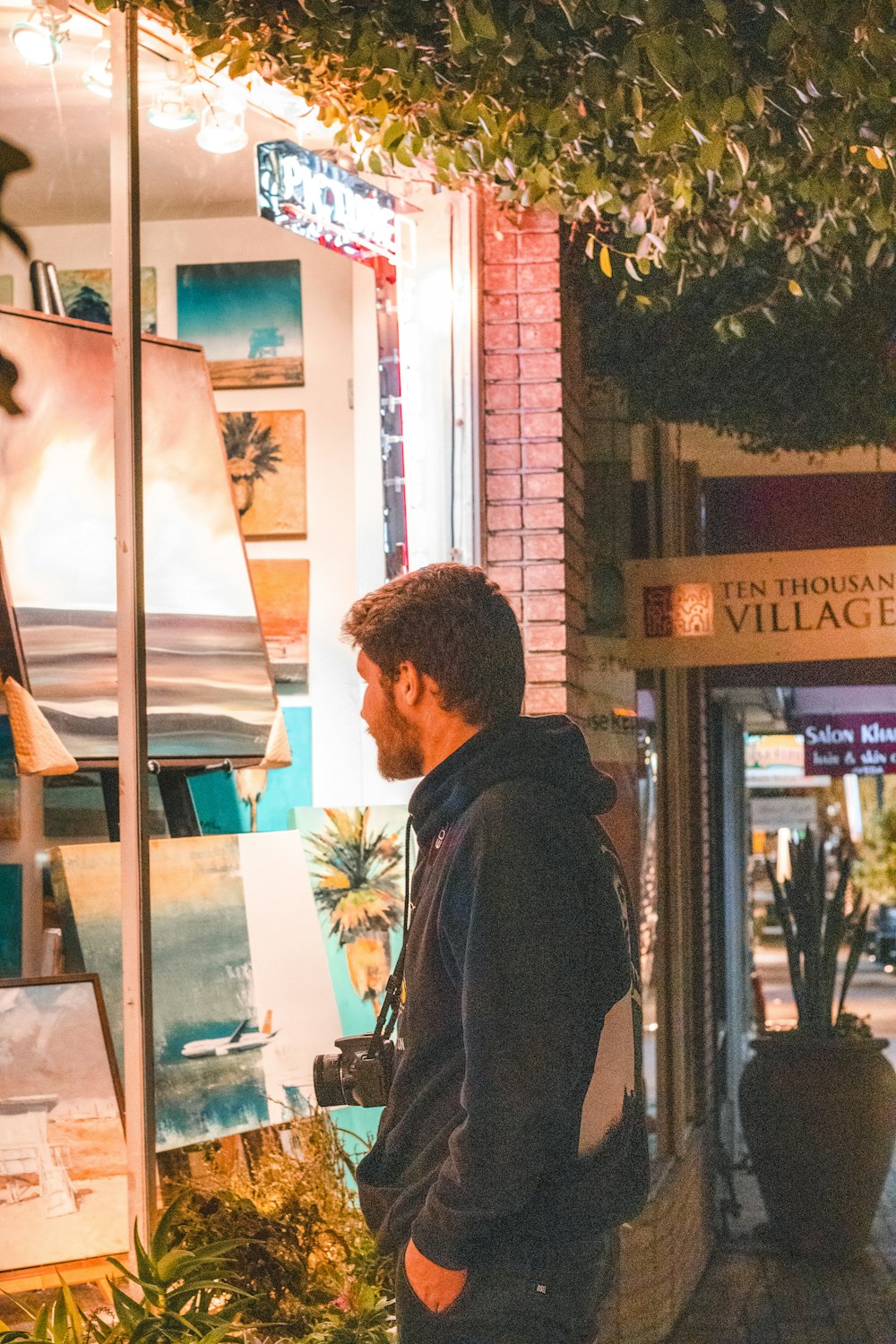 man in black jacket standing near store during daytime