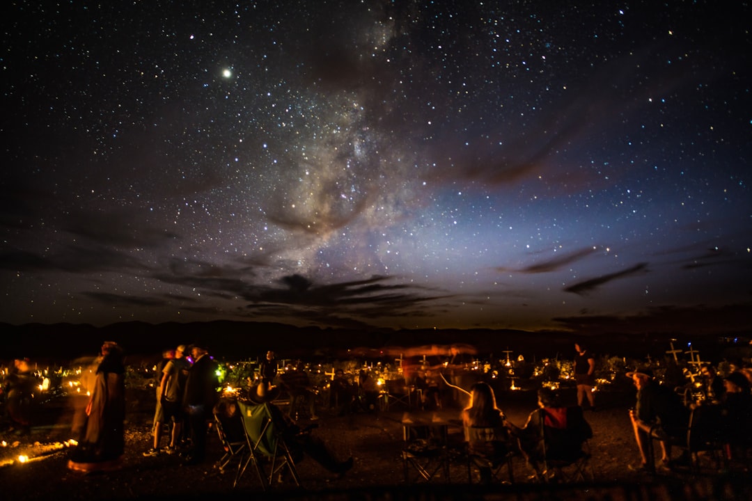 people standing on field under starry night