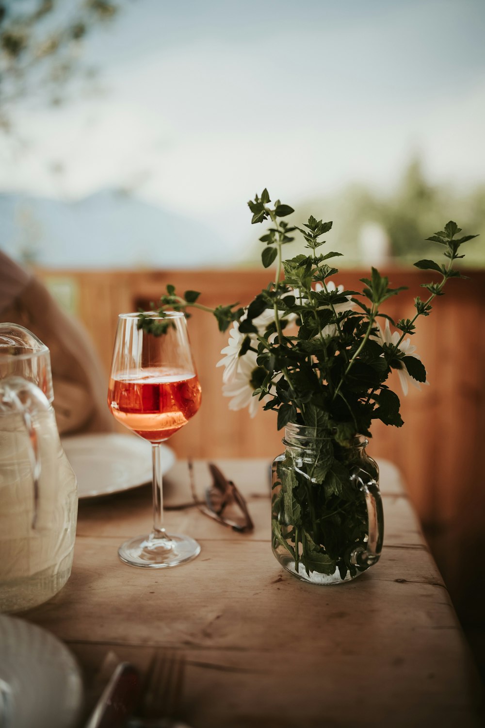 green plant in clear glass vase beside clear drinking glass