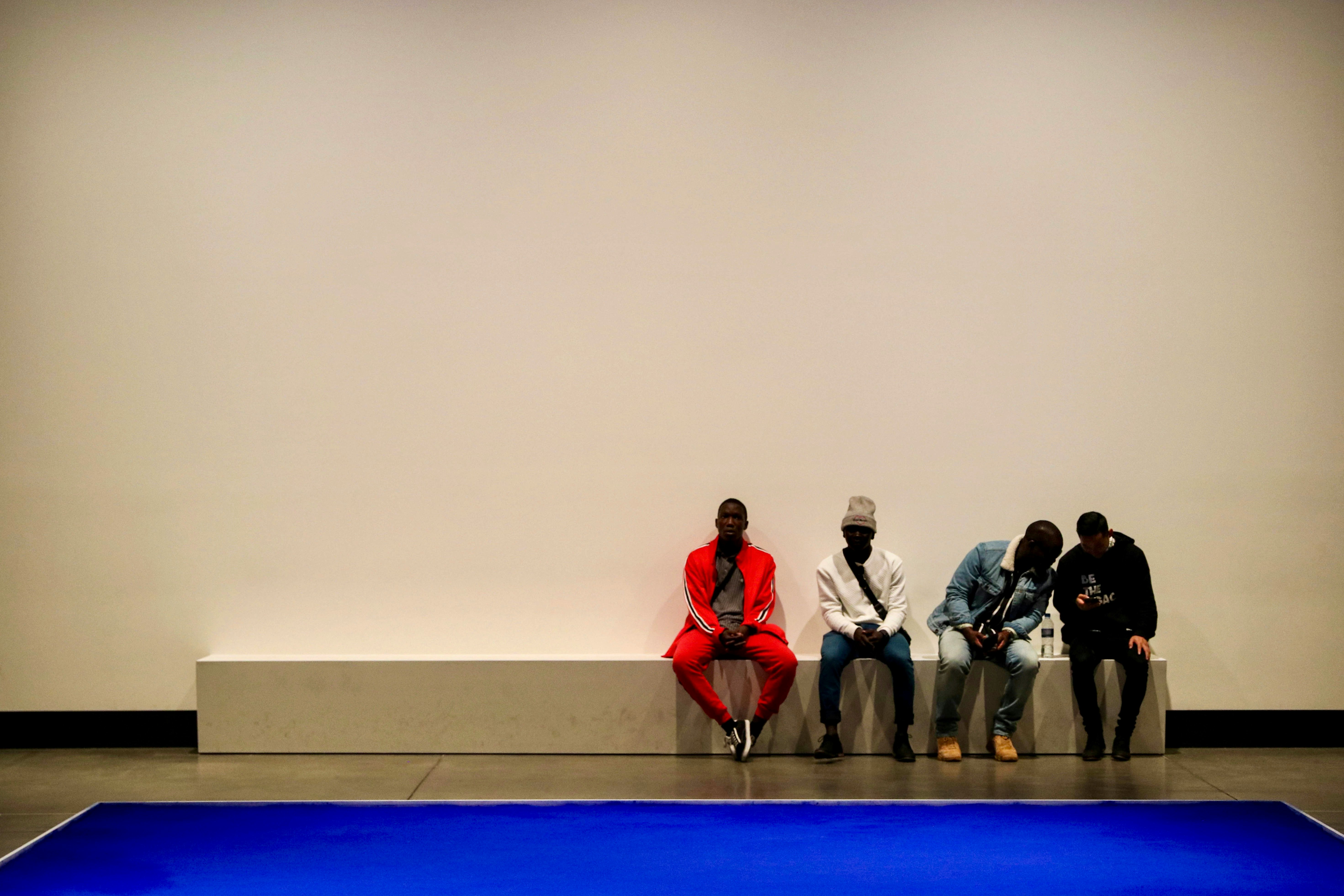 group of people sitting on blue floor