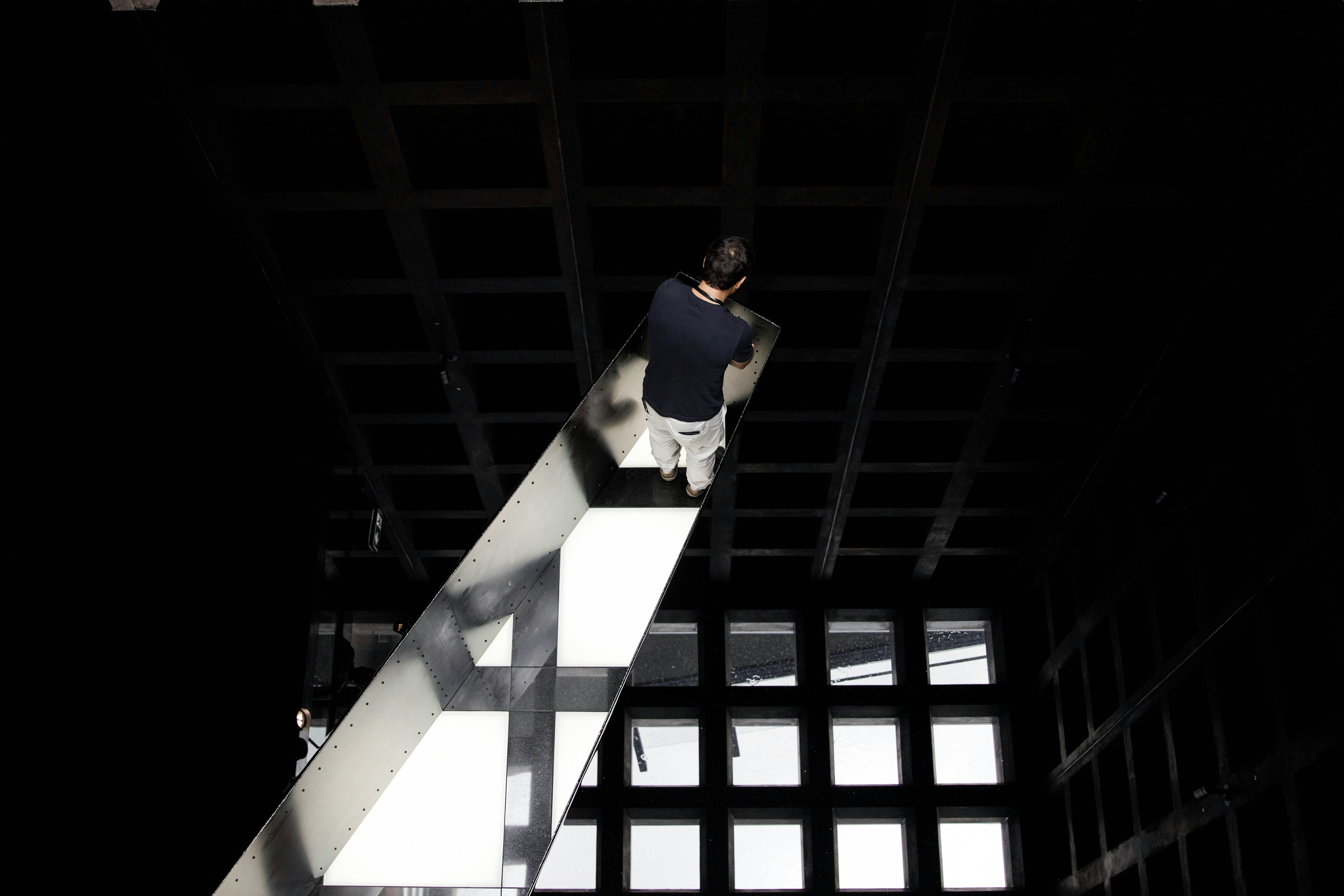 woman in blue shirt and black pants standing on white concrete building