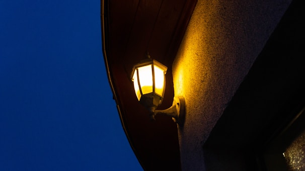 Solar wall lights casting a soft glow along a stone garden wall during evening.