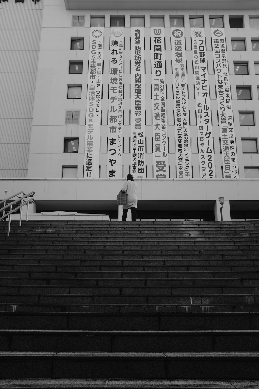 grayscale photo of man walking on stairs