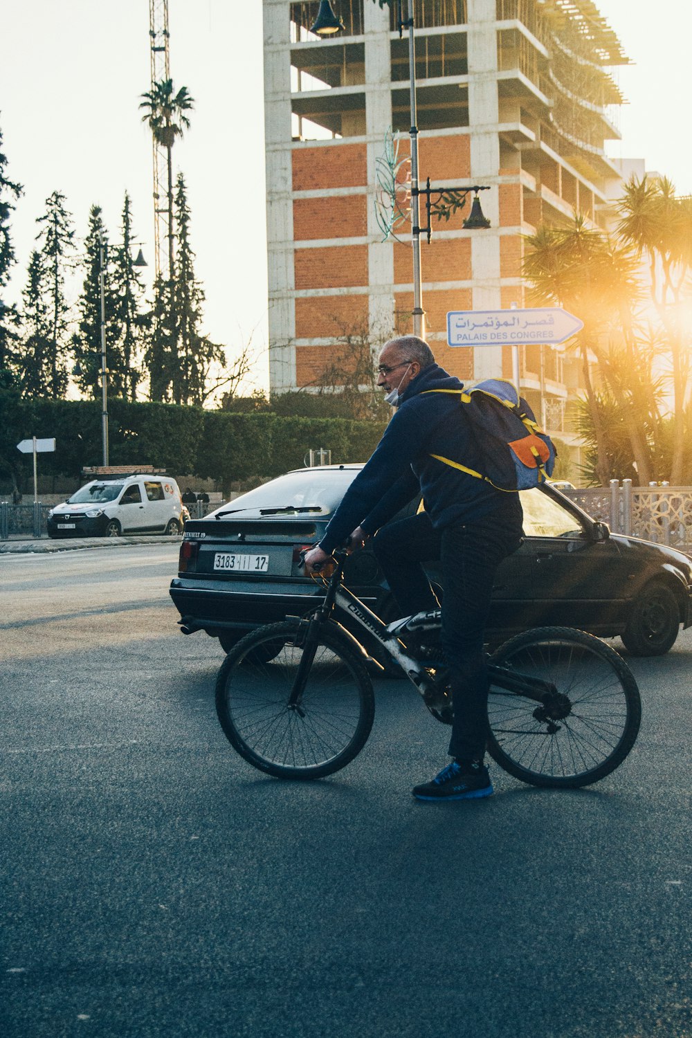 man in black jacket riding on black bicycle during daytime