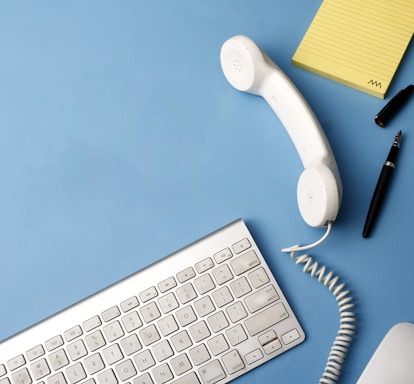 A cozy workspace with a vintage mobile phone and a laptop, symbolizing communication and history.