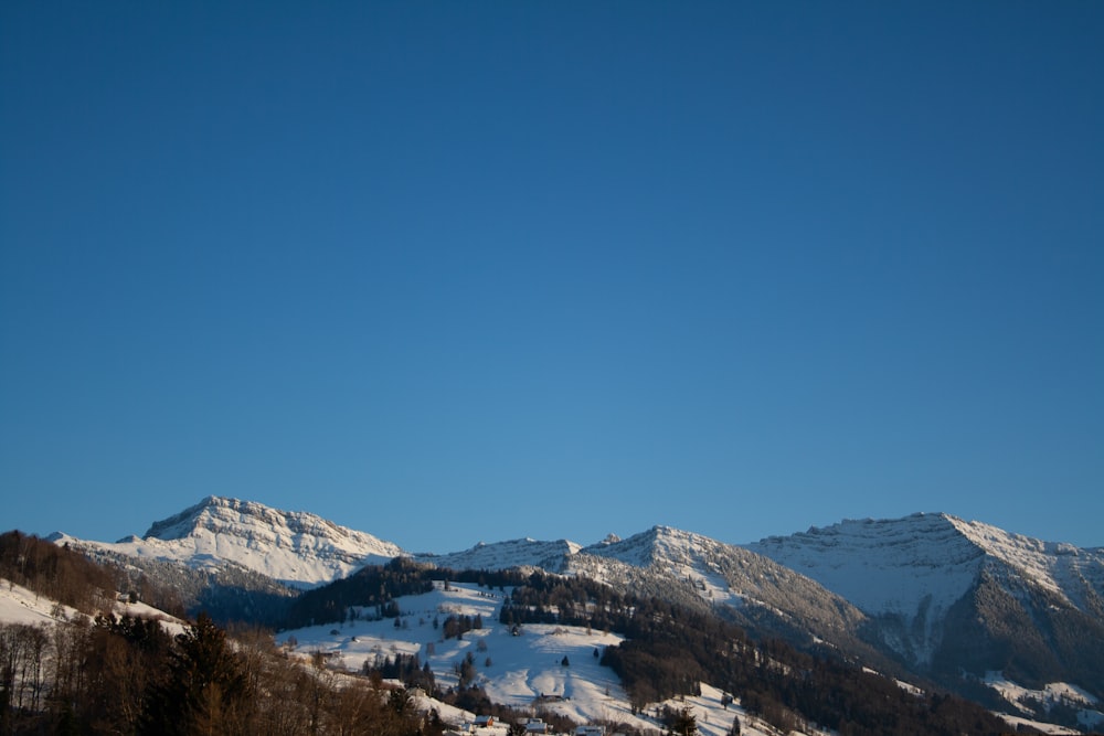 snow covered mountains under blue sky during daytime