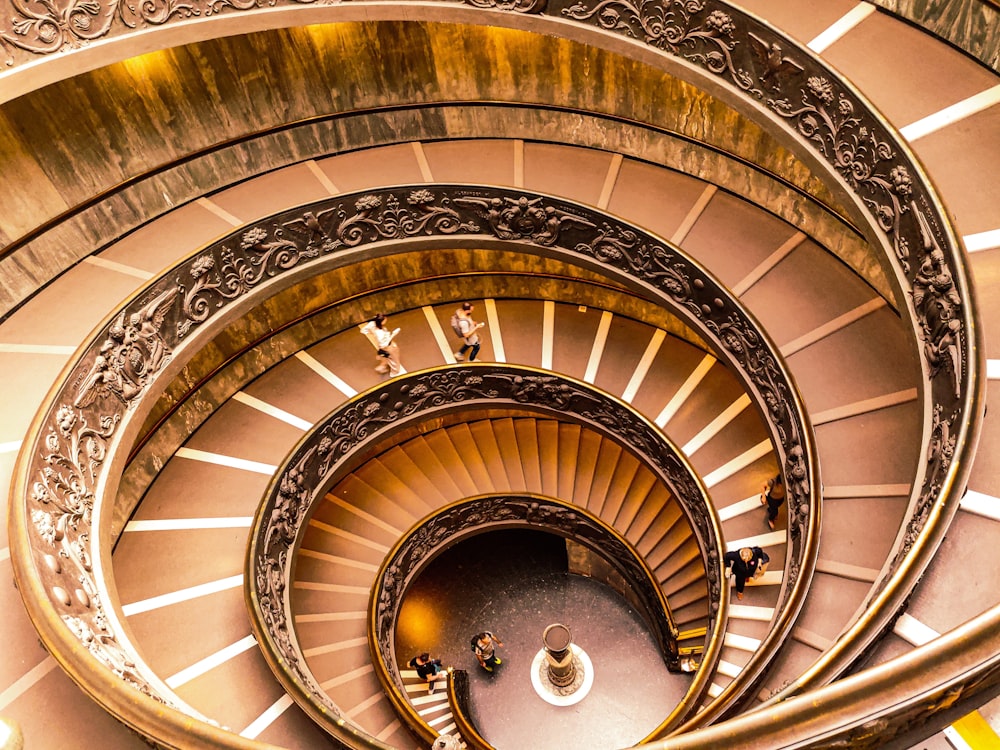 Escalera de caracol marrón con barandillas de madera blanca