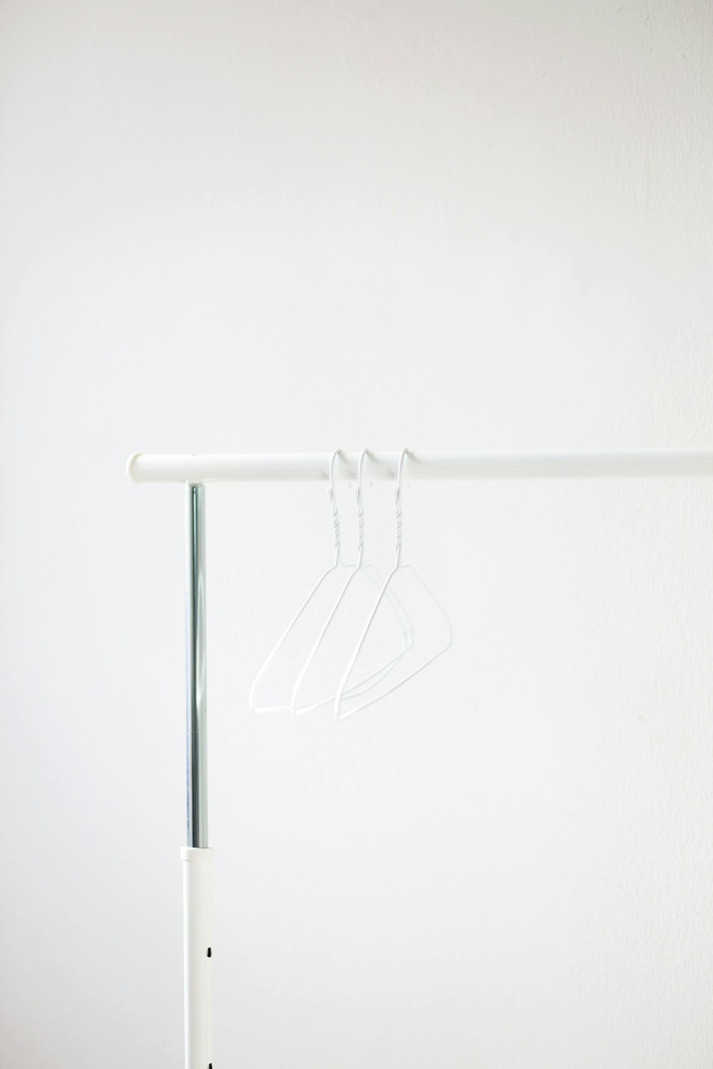 white clothes hanger on white metal bar