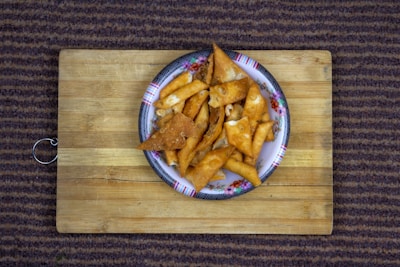 Close-up of crispy golden snacks arranged on a rustic wooden board