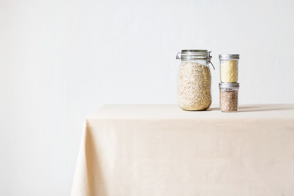 2 shakers à condiments en verre transparent sur table blanche