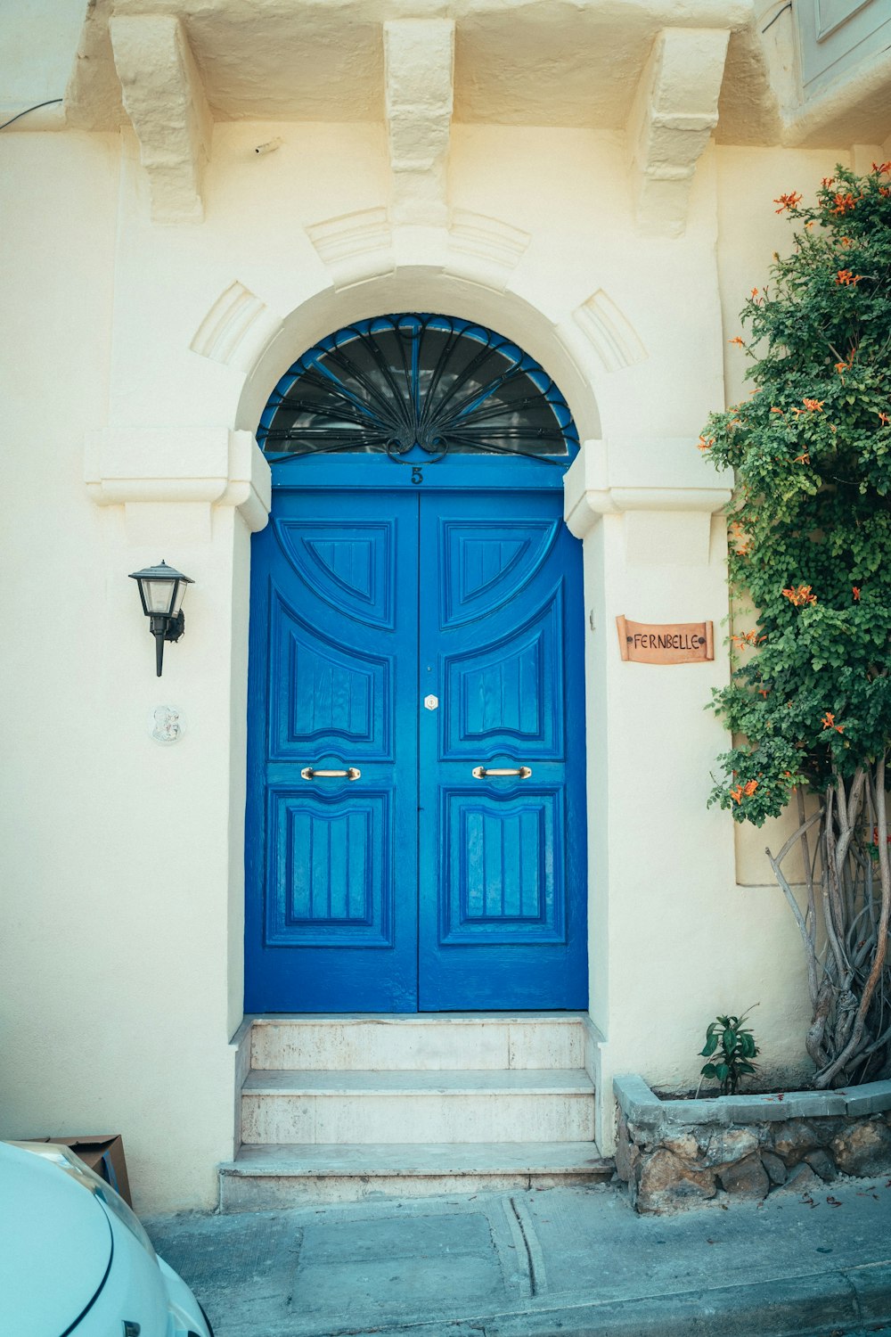 blue wooden door on white concrete building