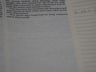 Close-up of hands highlighting verses in a Bible with colorful markers.