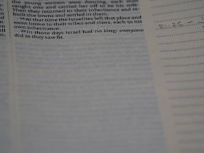 Close-up of hands highlighting verses in a well-worn Bible.