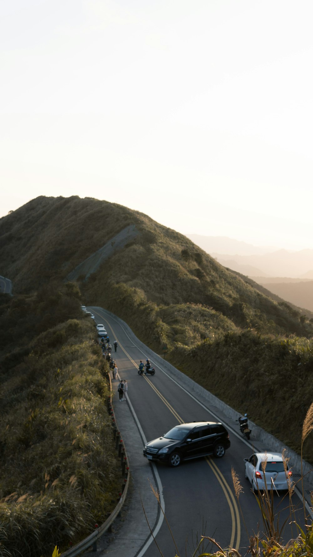 cars on road near mountain during daytime