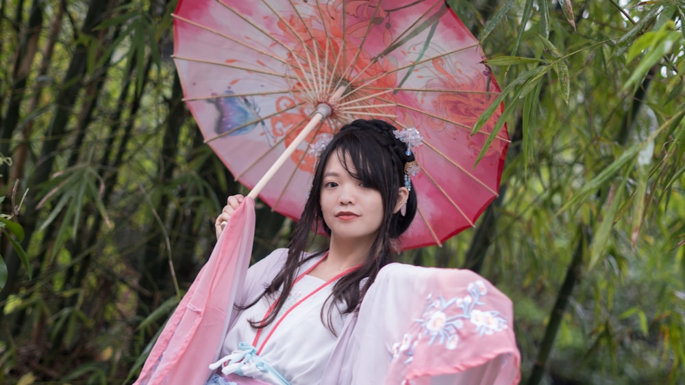 woman in white and pink floral kimono holding umbrella