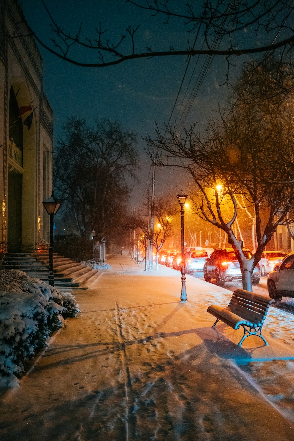 a bench sitting on the side of a snow covered road