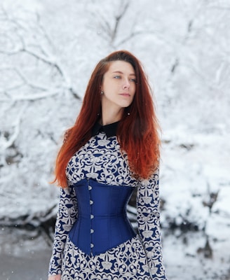 woman in black and white long sleeve dress standing on snow covered ground during daytime