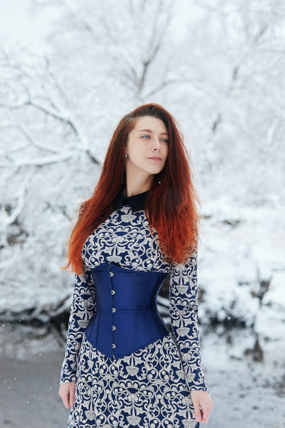 woman in black and white long sleeve dress standing on snow covered ground during daytime