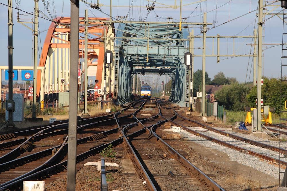orange and gray train on rail tracks during daytime