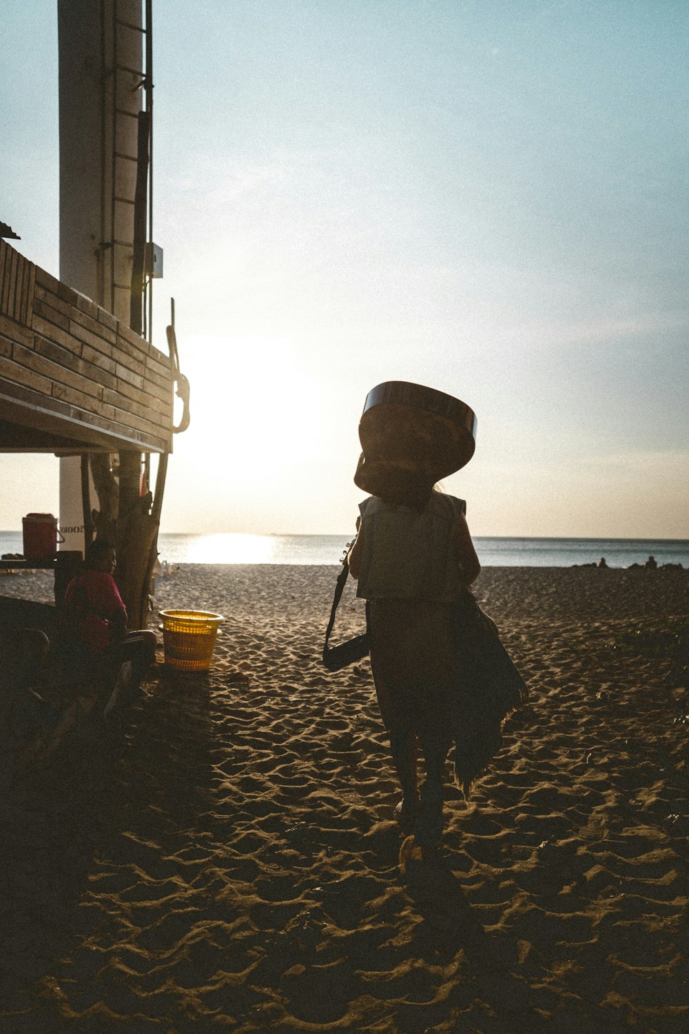 silhouette di persona in piedi sulla spiaggia durante il tramonto