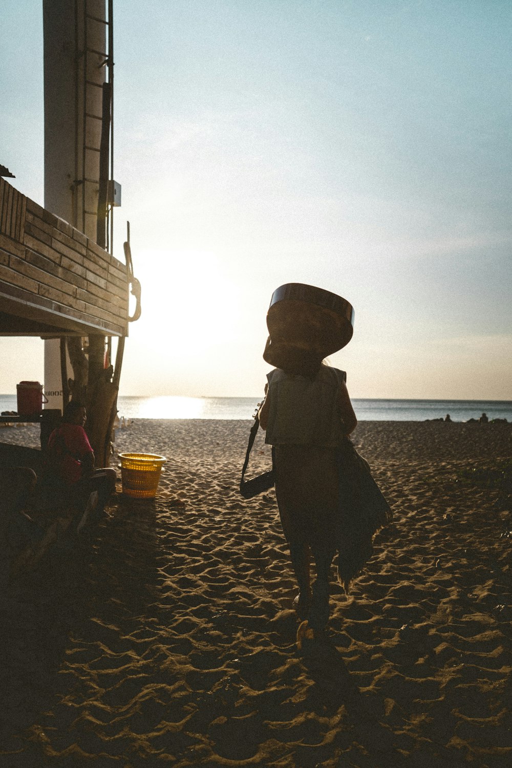 silhouette of person standing on beach during sunset