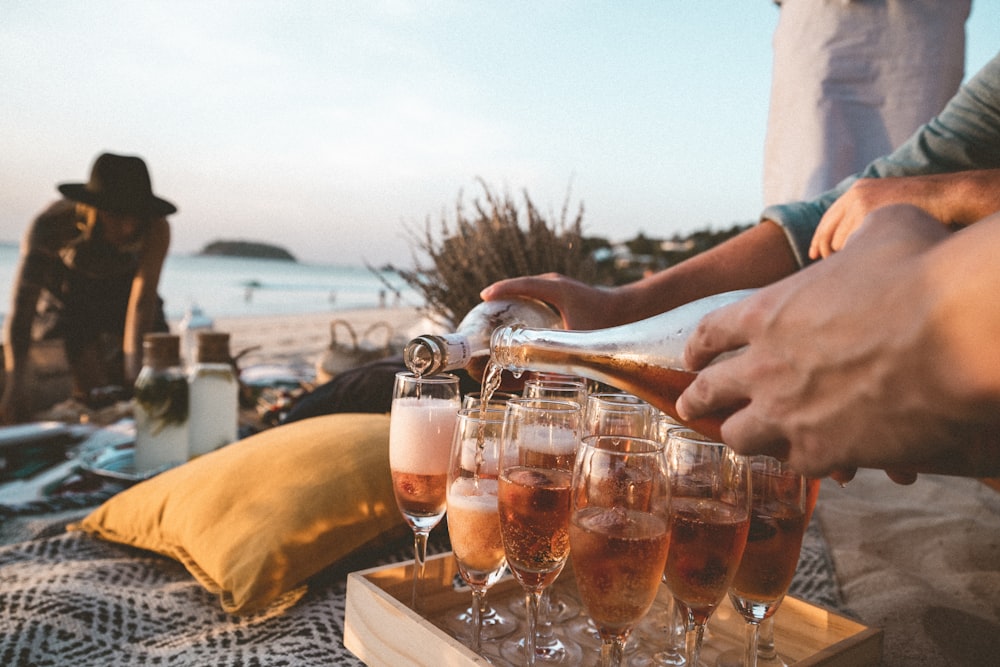 person pouring wine on clear drinking glass