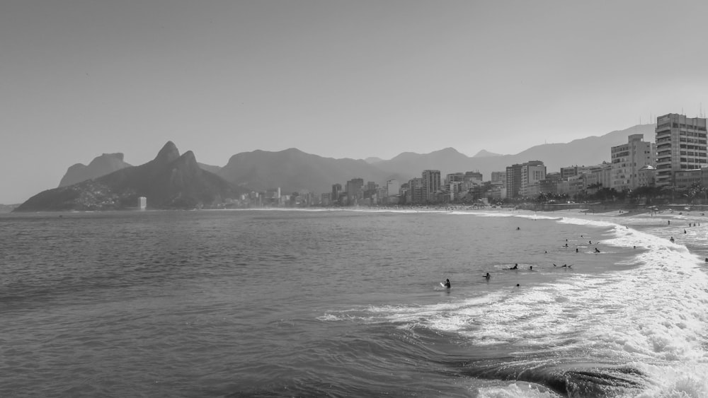 grayscale photo of people on beach